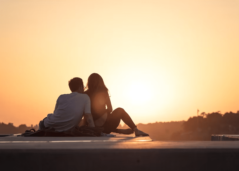 A couple seeing the sunset on a rooftop together.