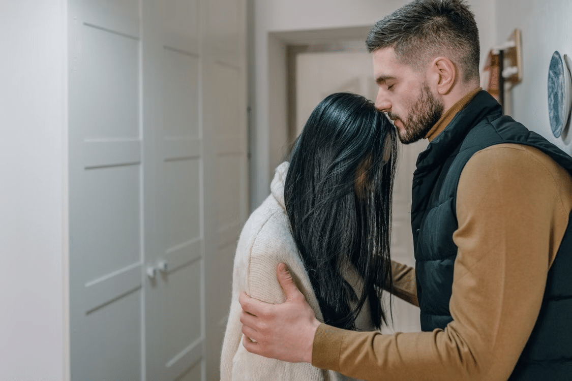 A woman making up after an argument as the man comforts her.