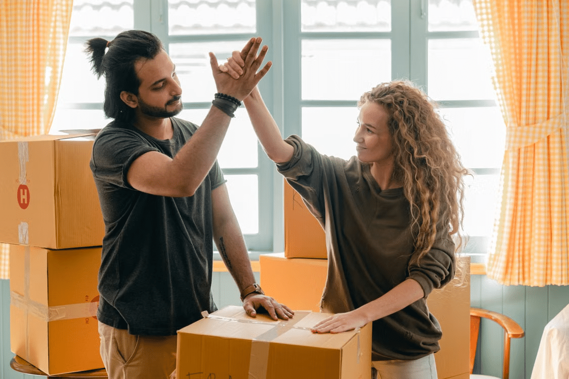A couple congratulating each other for achieving the milestone of buying their own house.