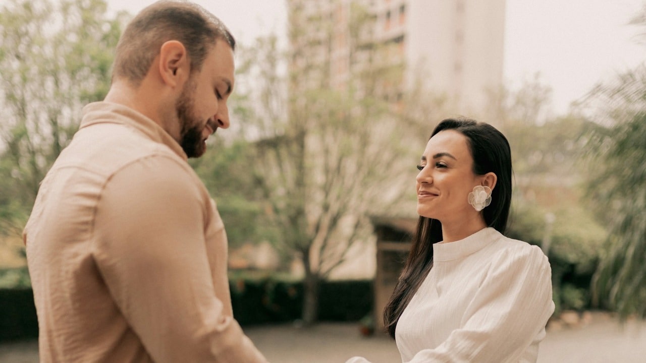 A man and a woman holding hands while standing outdoors.