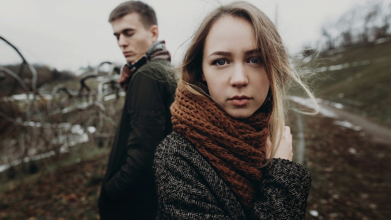 A sad couple standing outdoors.