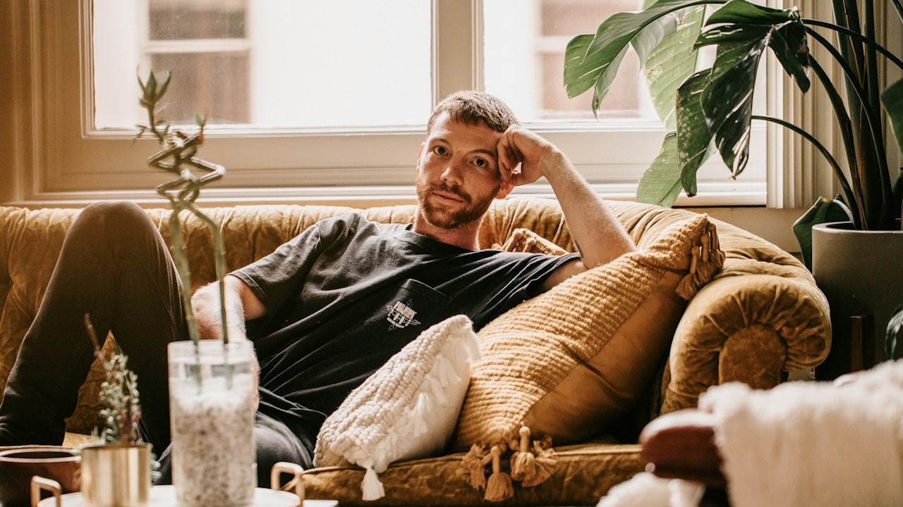 A man sitting on a couch and thinking about something.