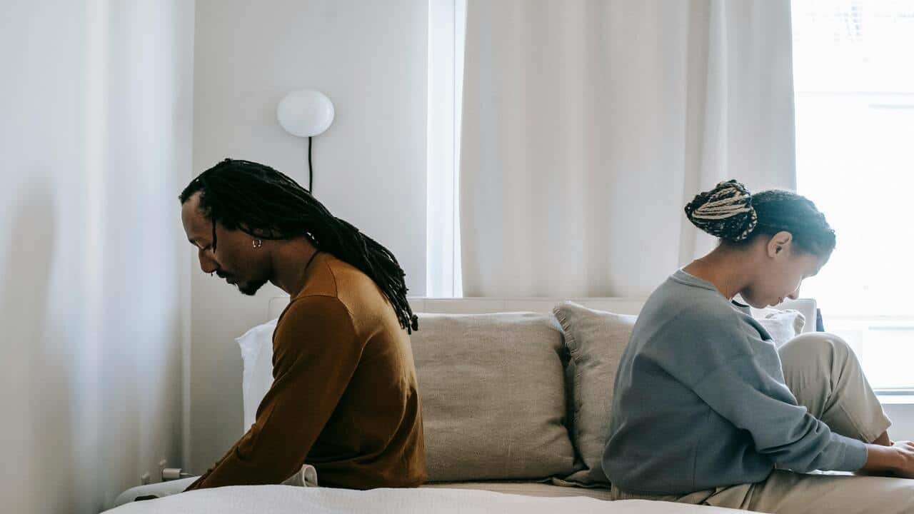 A couple looking sad in the bedroom