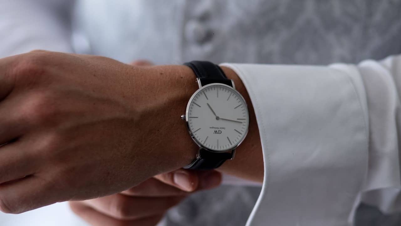 Close up of a man tightening a wristwatch.