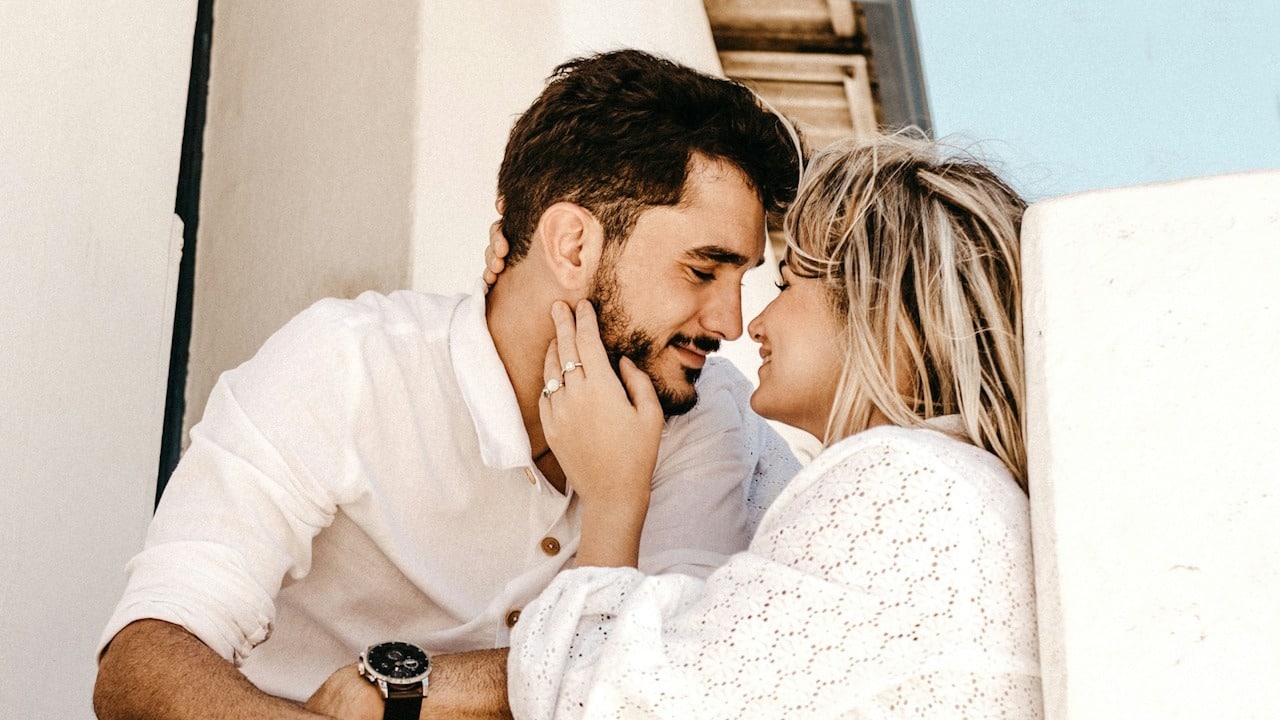 A young couple sharing an intimate moment outdoors.
