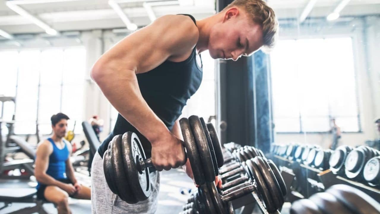 Man lifting weights in a clean, well lit gym