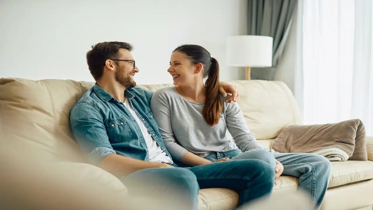 A couple talking and smiling in the living room