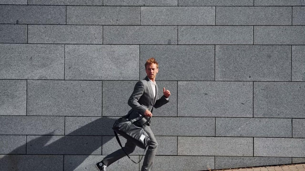 Man running after work while holding his gym bag