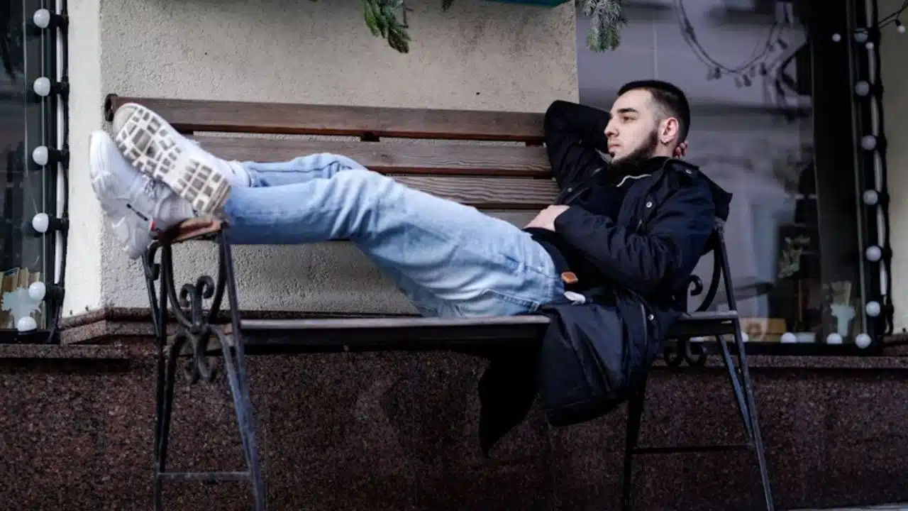 Man sitting alone on park bench looking emotionally drained
