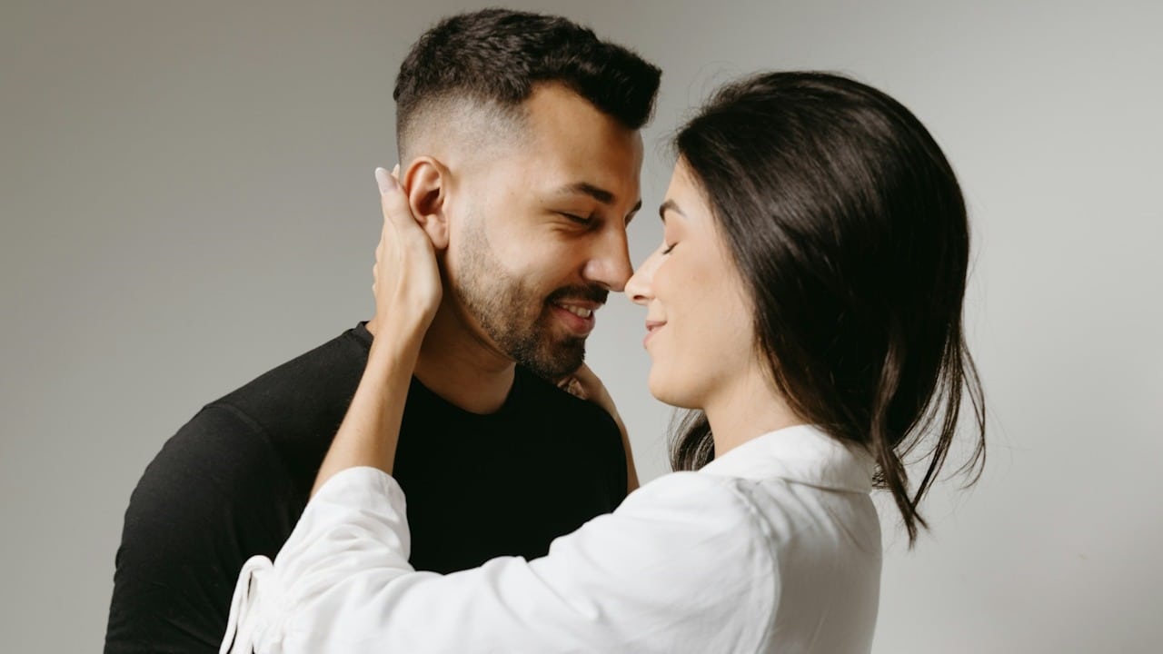A couple about to kiss with their eyes closed in anticipation.