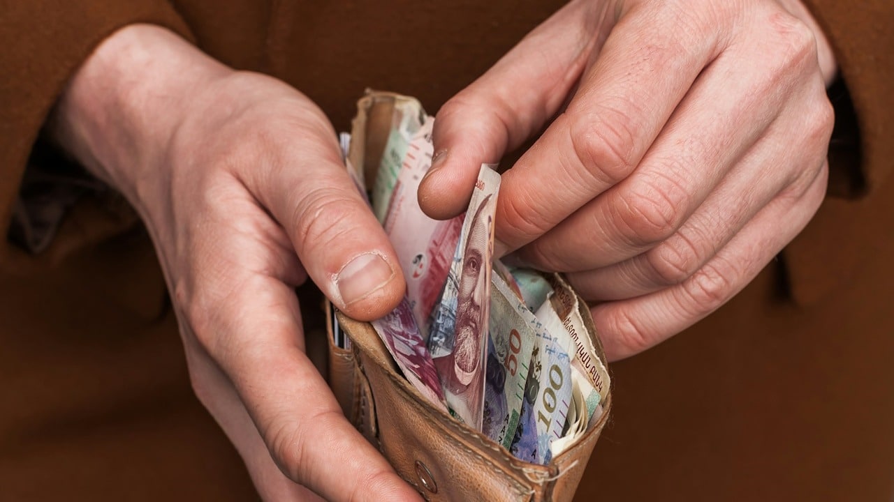 A man pulling out some money from the wallet