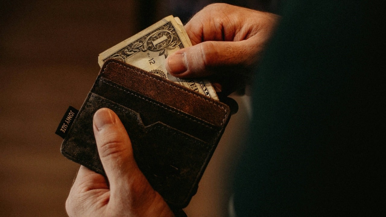 A man pulling out some money from the wallet