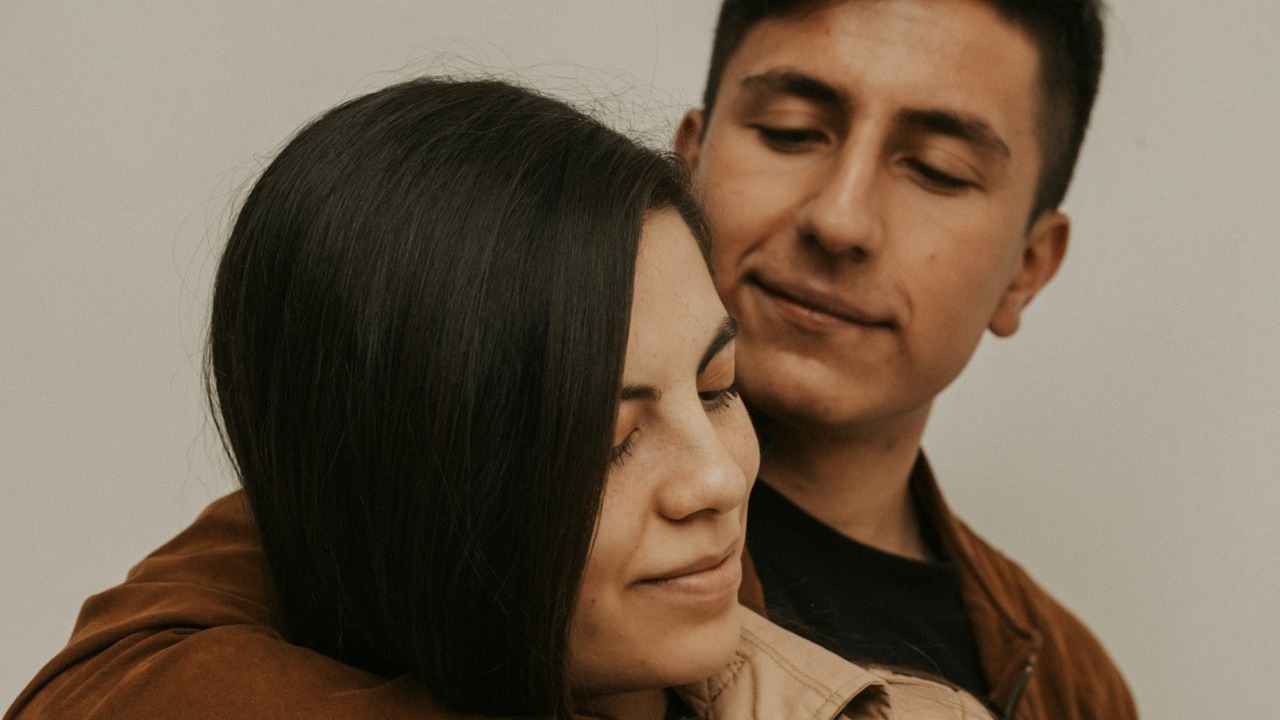 A man holding his woman from behind.