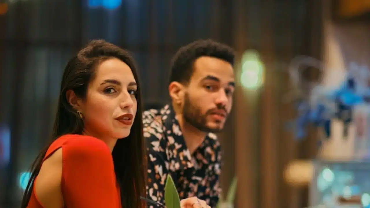 Couple sitting apart at a table avoiding eye contact