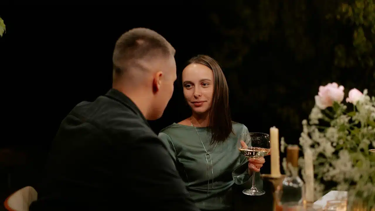 A beautiful couple sitting at a dinner table.