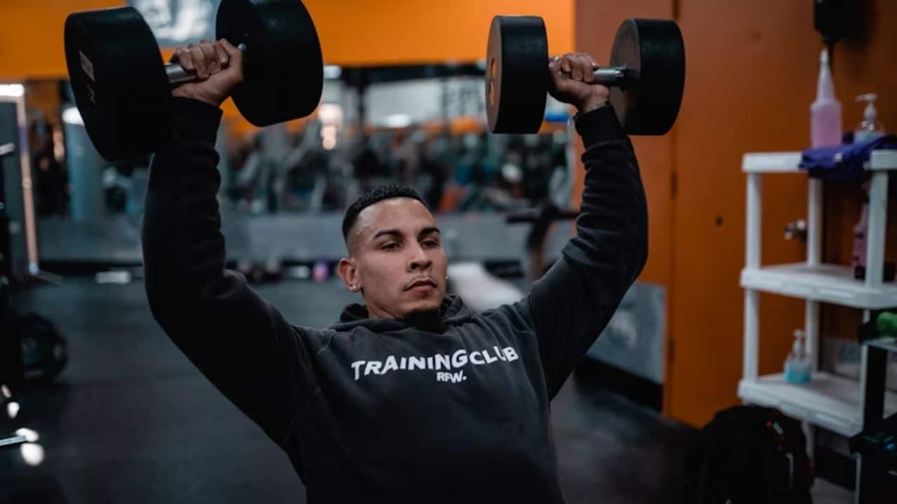 Man at the gym lifting weights with determination