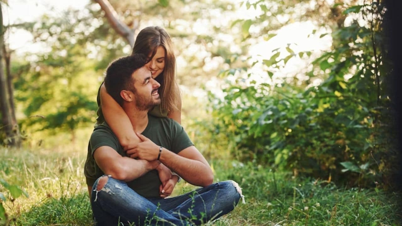 Woman smiling and hugging her partner from behind