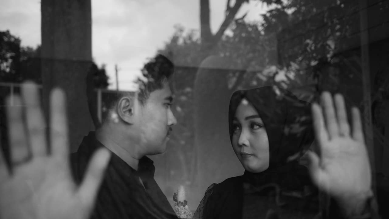 A man and a woman looking out of a window.
