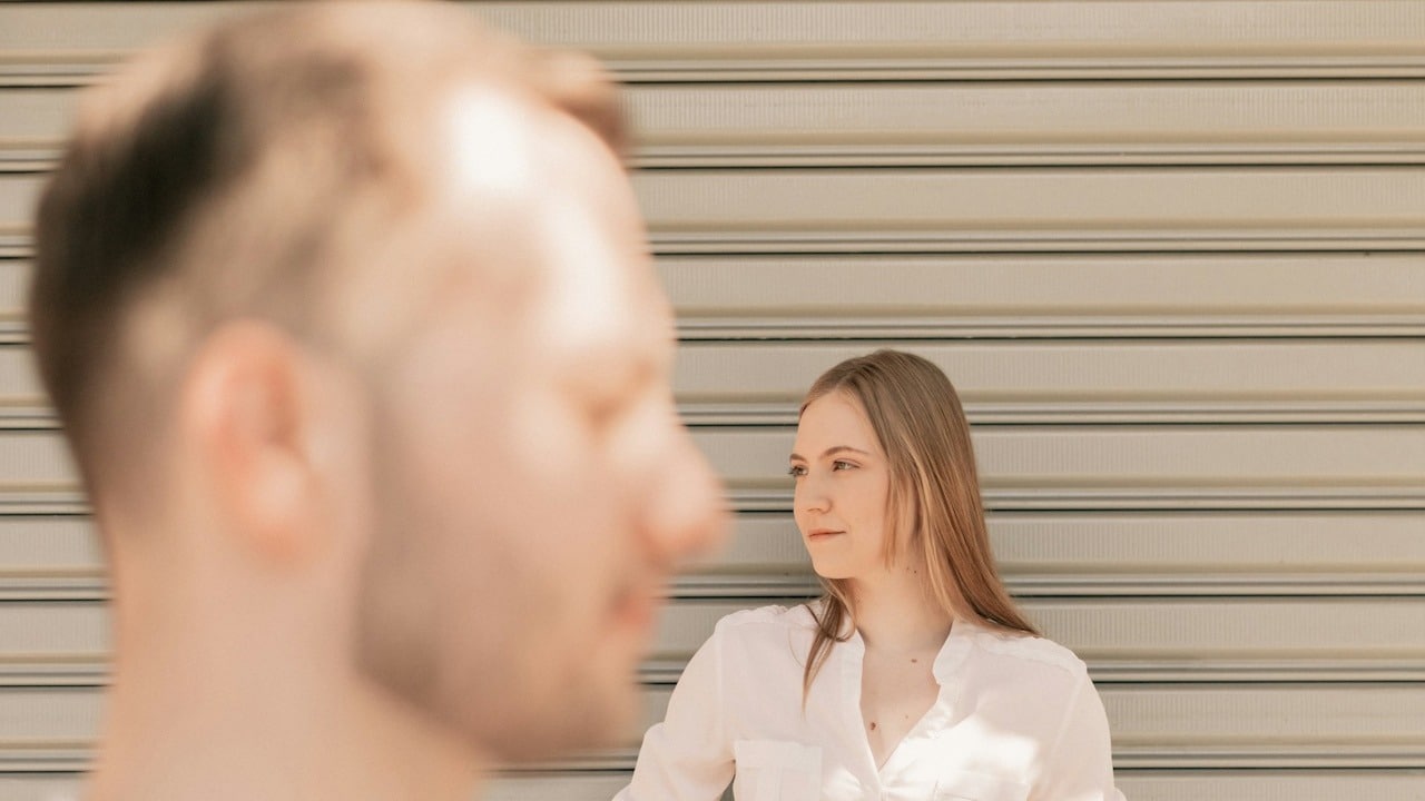 A man and a woman standing in front of a garage door.