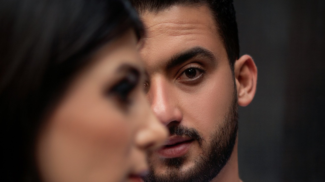 An indifferent woman standing next to a man.