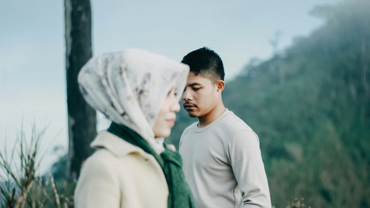A man standing next to a woman outdoors.