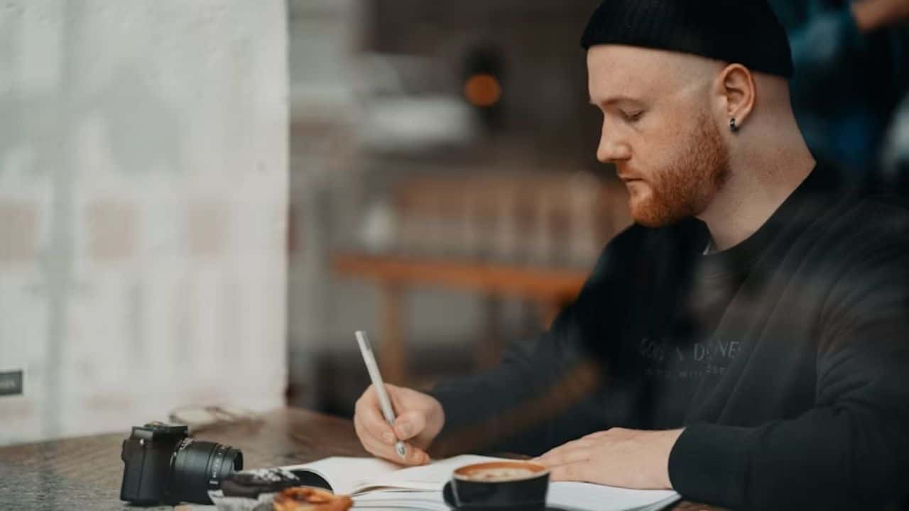 Man journaling or enjoying coffee alone in the morning