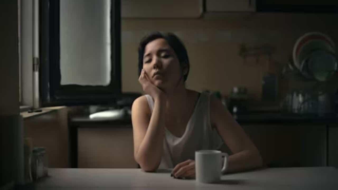 Woman sitting at the kitchen table feeling exhausted