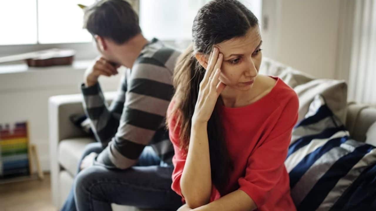 Couple sitting on opposite sides of the couch in silence