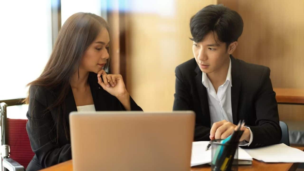 A couple having a tense conversation while reviewing bills