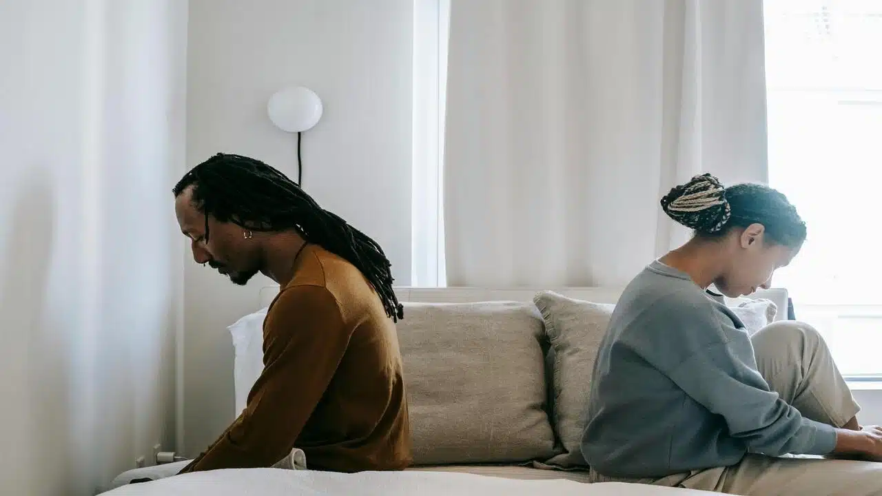 A couple looking sad in the bedroom