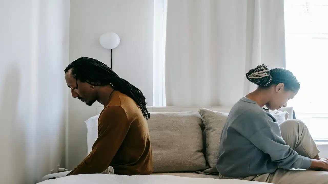 A couple looking sad in the bedroom
