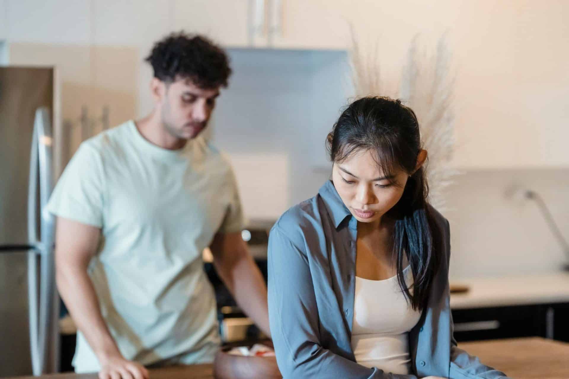 A sad woman with a man in the background.