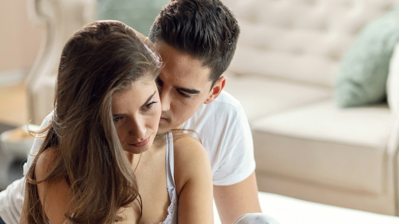 A man trying to kiss a woman who’s pulling away.