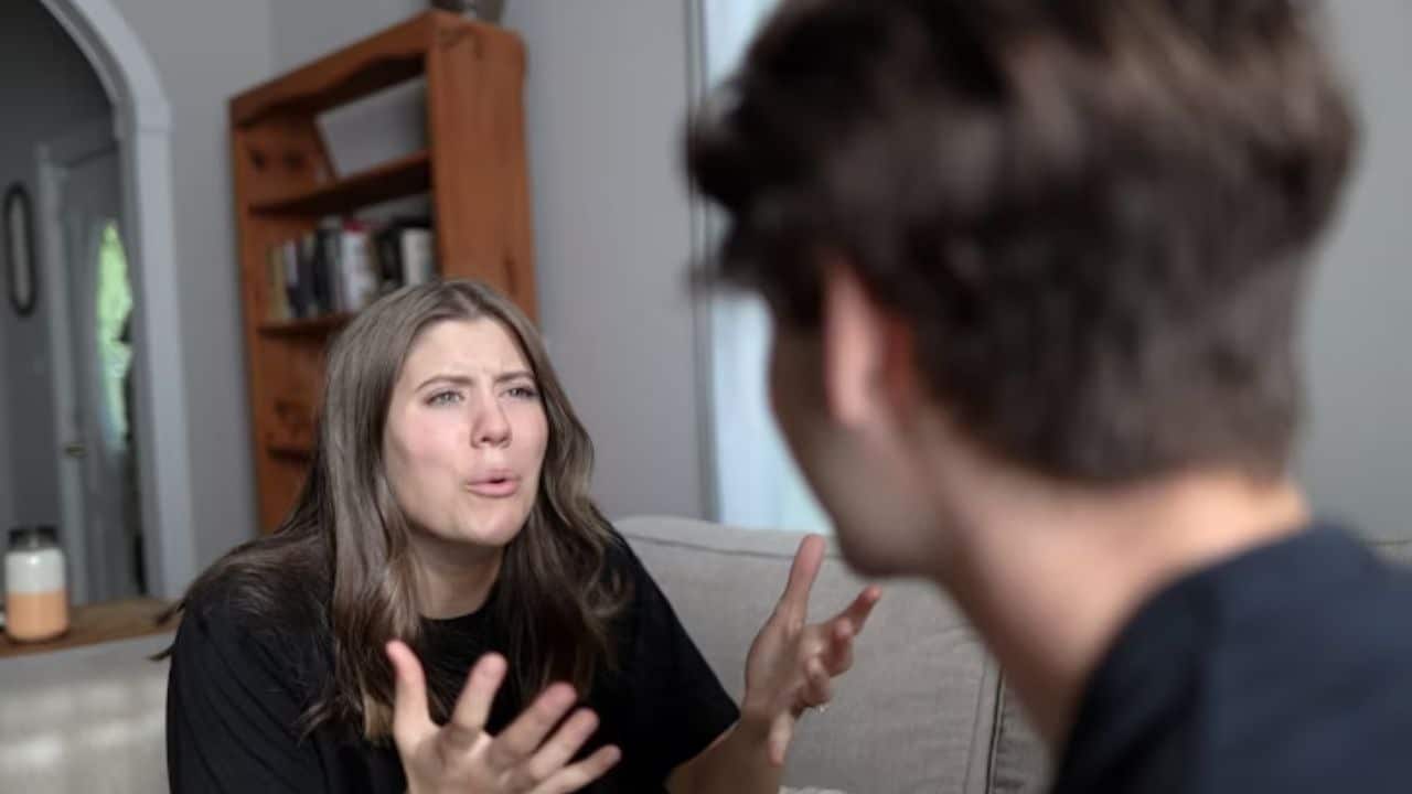 Woman gesturing angrily while man listens