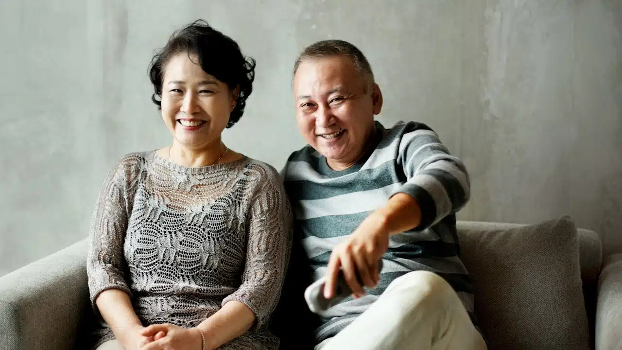 A mature couple sitting together indoors.