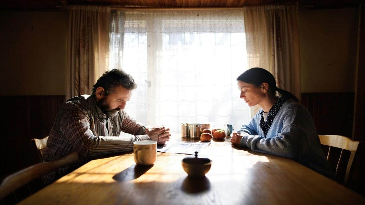 A couple looking sad at the dining table