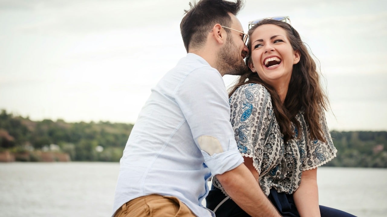 Happy, beautiful couple in love smiling and laughing outdoors.
