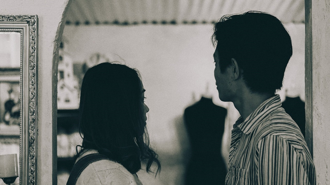 A man looking at a woman who’s looking away from him.