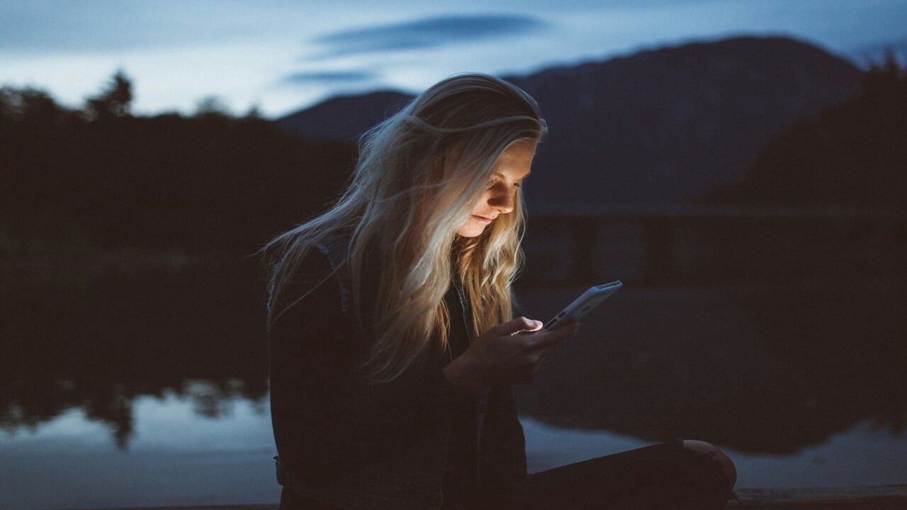 A woman texting in the dark