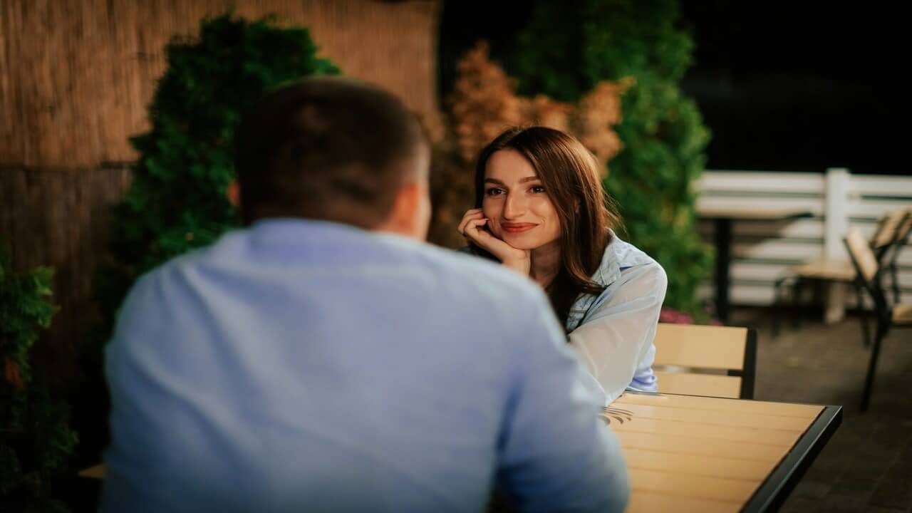 A woman looking at a man with a smile