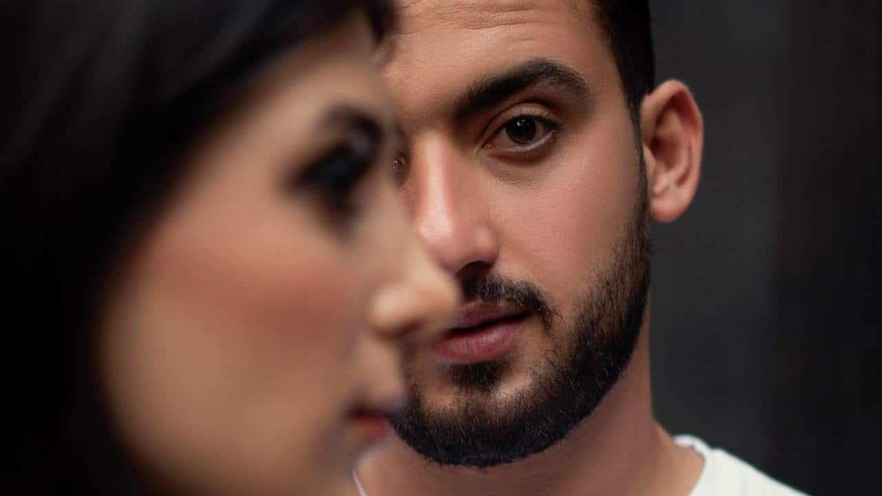 A bearded man looking at a woman.