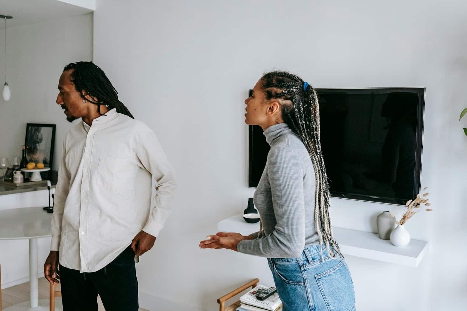 A woman looking confused as her partner looks away from her mid-conversation.