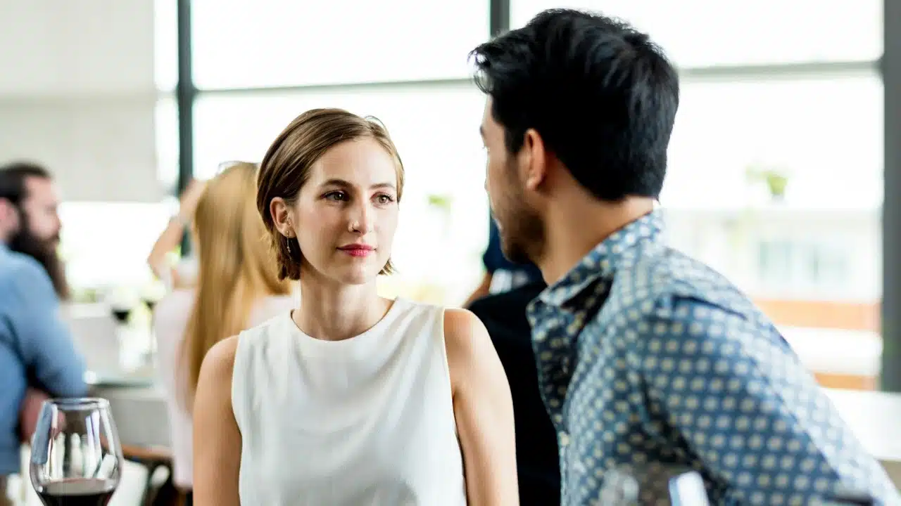 A woman staring at a man while they sit at a table in a restaurant.