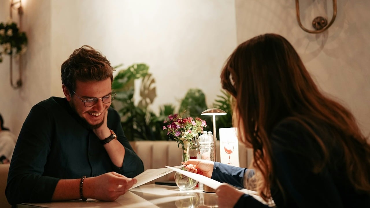 A man and woman sitting at a restaurant table.