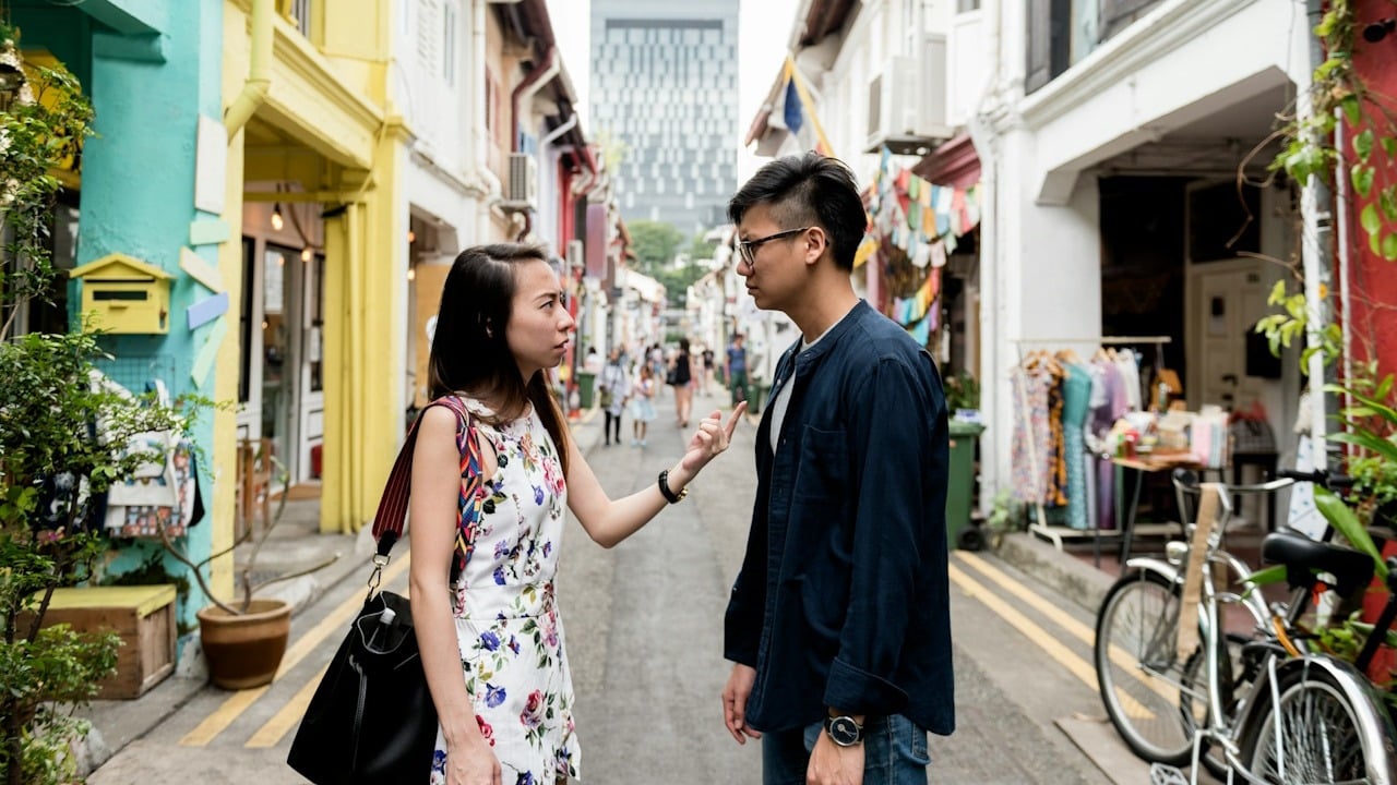 A woman pointing at a man while standing in a street.