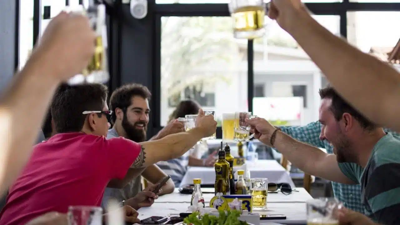 A man having drinks with friends outdoors