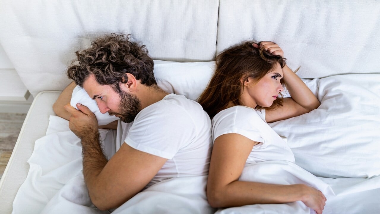 A couple looking upset in bed