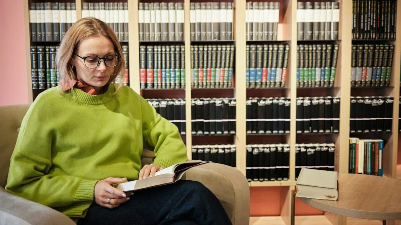 A woman reading a book in a legal advisor's office.