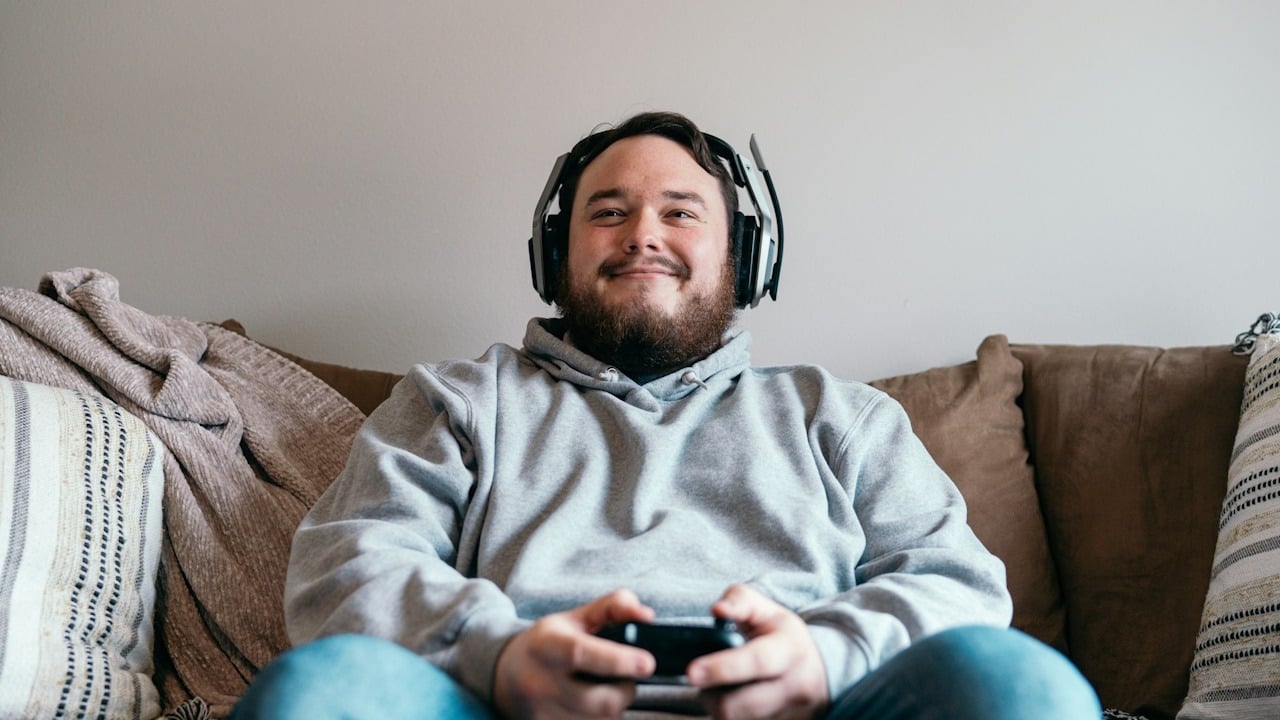 A smiling man playing video games.