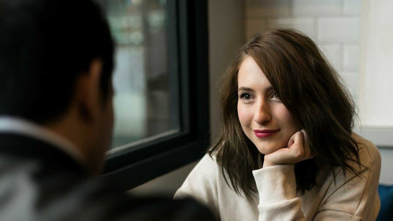 A woman smiling and staring into a man’s eyes.